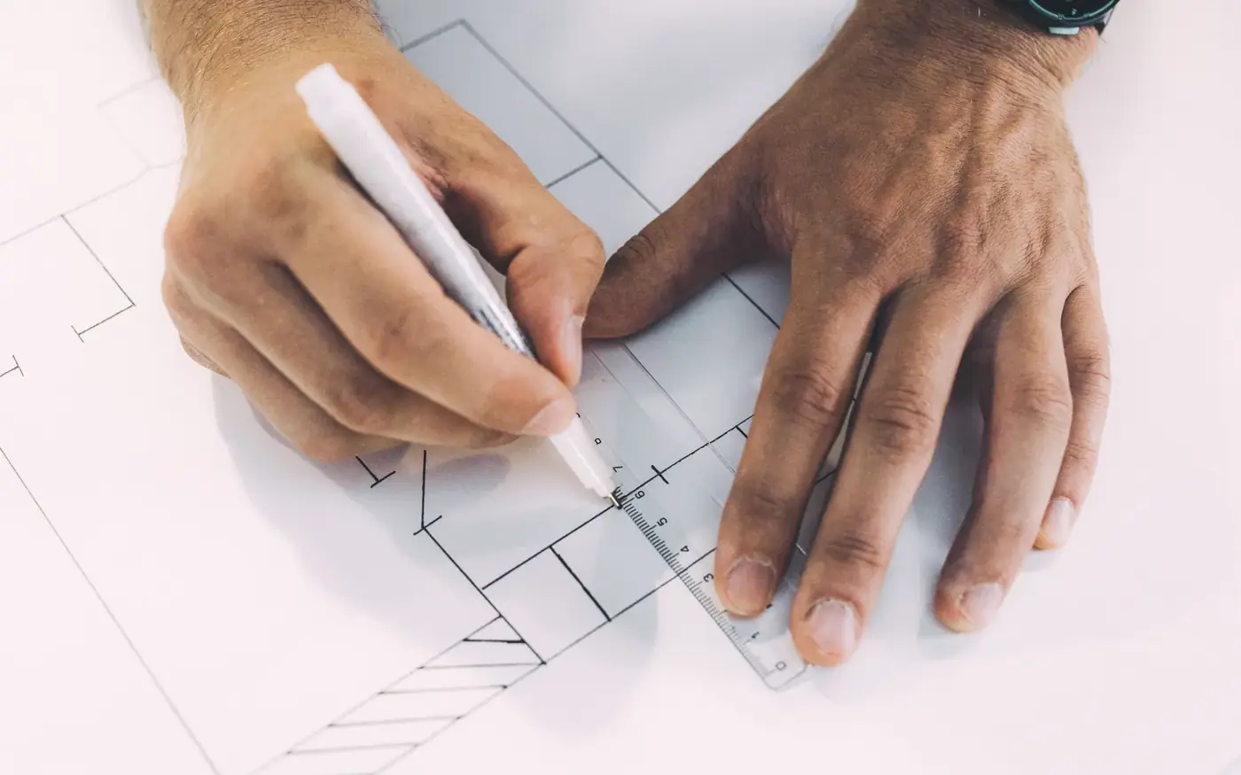 Hands working through paperwork on a desk with a pen