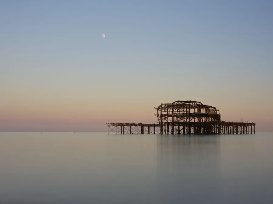 The remains of Brighton West Pier at dusk, seen from the seafront